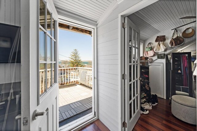 entryway featuring wooden walls, wooden ceiling, wood finished floors, and lofted ceiling