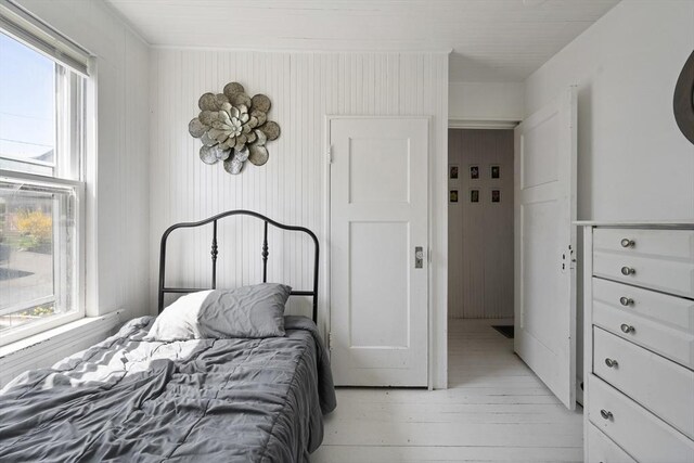 bedroom featuring multiple windows and light wood finished floors