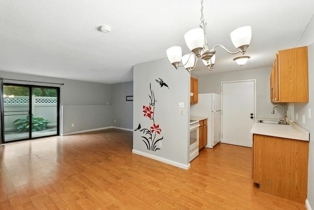 49 Village Brook Ln Unit 2, Natick, MA 01760 - kitchen with white appliances, light countertops, light wood-style floors, a chandelier, and brown cabinetry