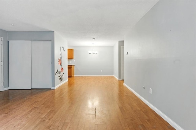 49 Village Brook Ln Unit 2, Natick, MA 01760 - unfurnished living room featuring a chandelier and light wood-style flooring