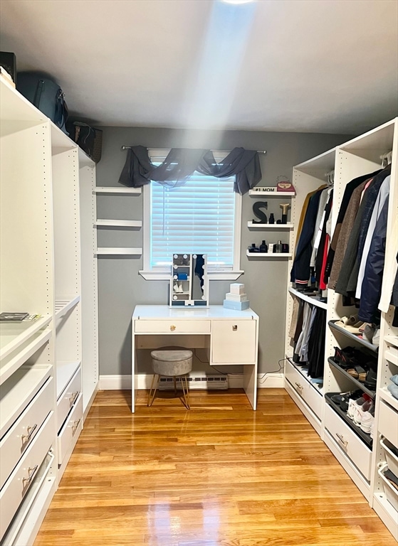 walk in closet with light hardwood / wood-style floors