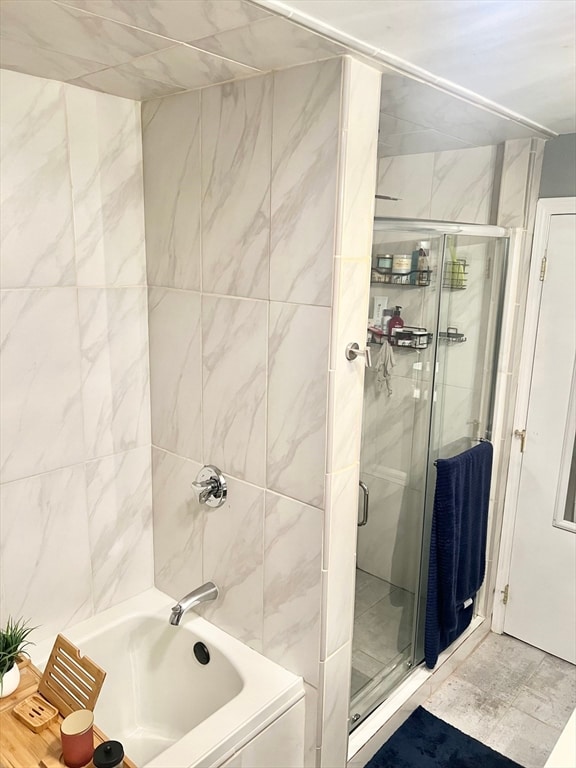 bathroom with tile walls and separate shower and tub