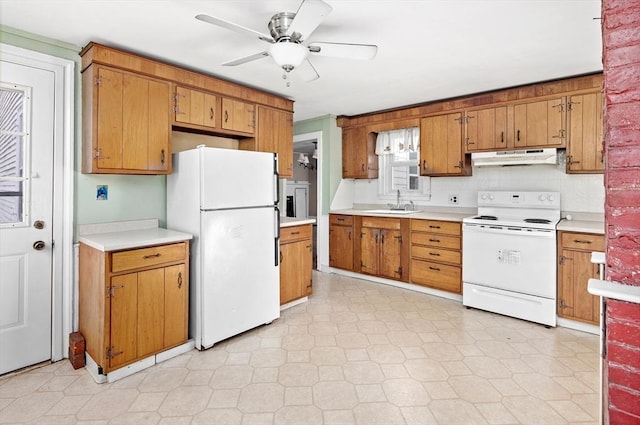 kitchen with under cabinet range hood, light countertops, a sink, white appliances, and ceiling fan