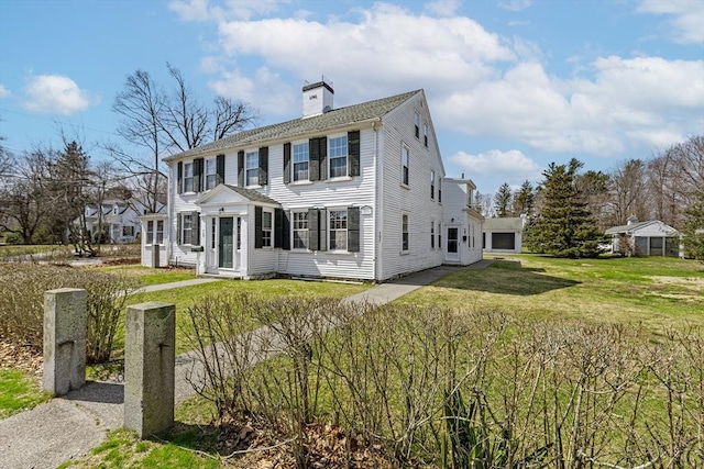 colonial inspired home featuring a front lawn, entry steps, and a chimney