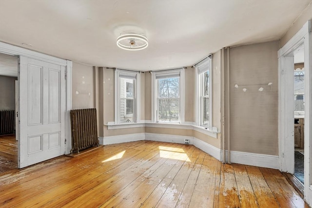 interior space featuring radiator, light wood finished floors, and baseboards