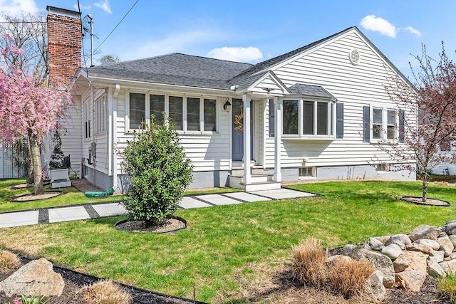 ranch-style home with roof with shingles, a front yard, a chimney, and entry steps