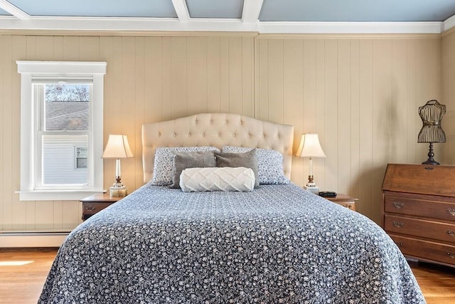 bedroom with crown molding, a baseboard radiator, and wood finished floors