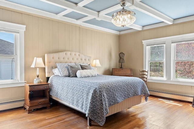 bedroom featuring a baseboard radiator, beamed ceiling, wood finished floors, and a chandelier