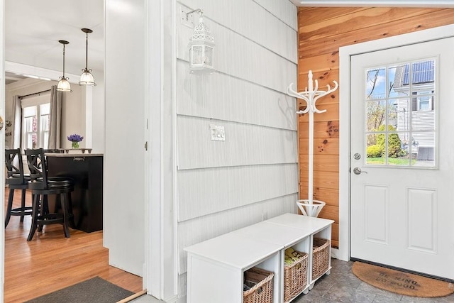 mudroom featuring wood walls and a wealth of natural light