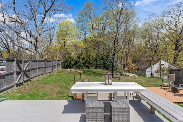 wooden deck with fence, outdoor dining area, and a lawn
