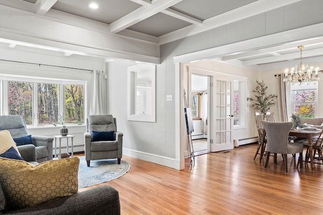 sitting room with an inviting chandelier, light wood finished floors, baseboards, a baseboard heating unit, and coffered ceiling