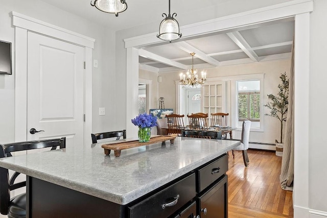kitchen with hanging light fixtures, beam ceiling, baseboard heating, light wood finished floors, and coffered ceiling