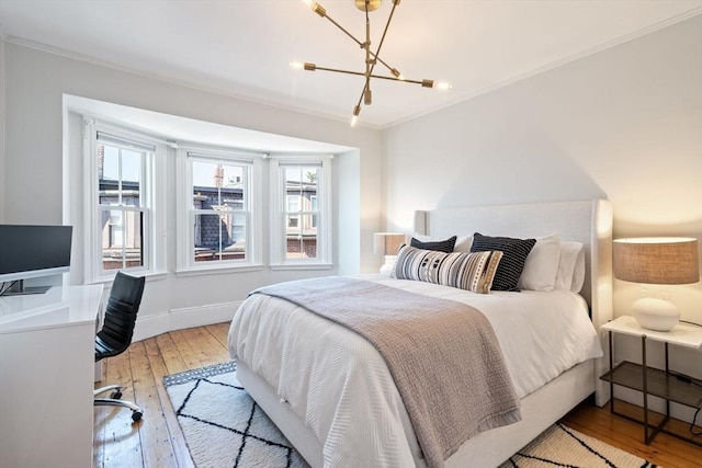 bedroom with a chandelier, light hardwood / wood-style floors, multiple windows, and ornamental molding