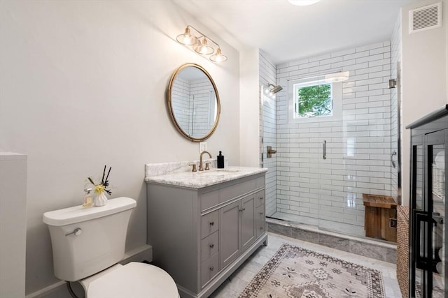 bathroom with tile patterned flooring, toilet, an enclosed shower, and vanity