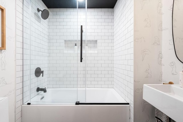 bathroom with sink and bath / shower combo with glass door