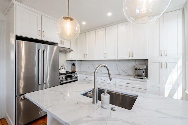 kitchen featuring tasteful backsplash, light stone counters, white cabinetry, and appliances with stainless steel finishes