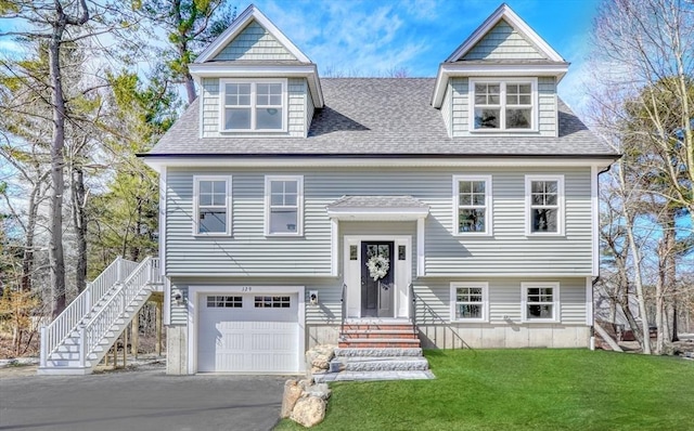 view of front of home featuring a front lawn, an attached garage, roof with shingles, and aphalt driveway