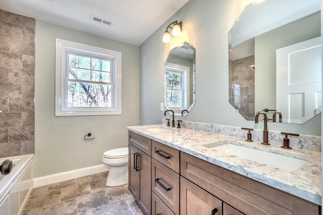 bathroom featuring toilet, visible vents, baseboards, and a sink