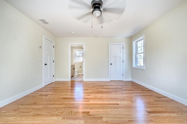 empty room with visible vents, baseboards, light wood-type flooring, and ceiling fan