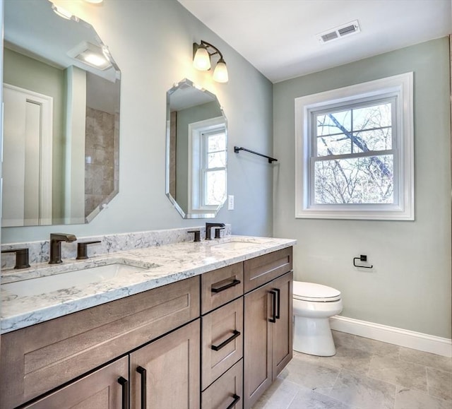 full bath with toilet, baseboards, visible vents, and a sink