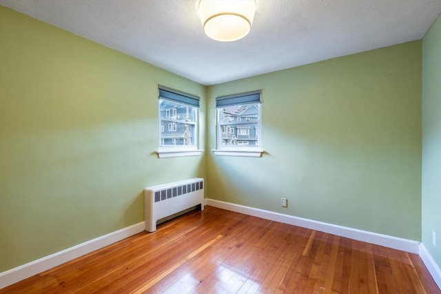 22 Sherman Ave, Northampton, MA 01060 - empty room with radiator heating unit, baseboards, and hardwood / wood-style floors