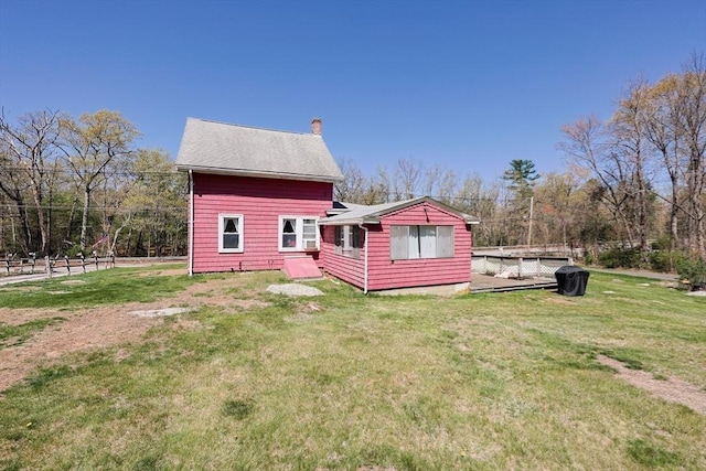 back of property with a lawn and a chimney