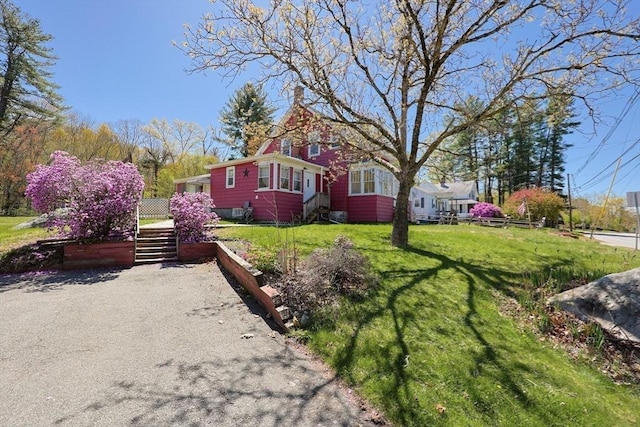 view of front of house featuring a front lawn and a chimney