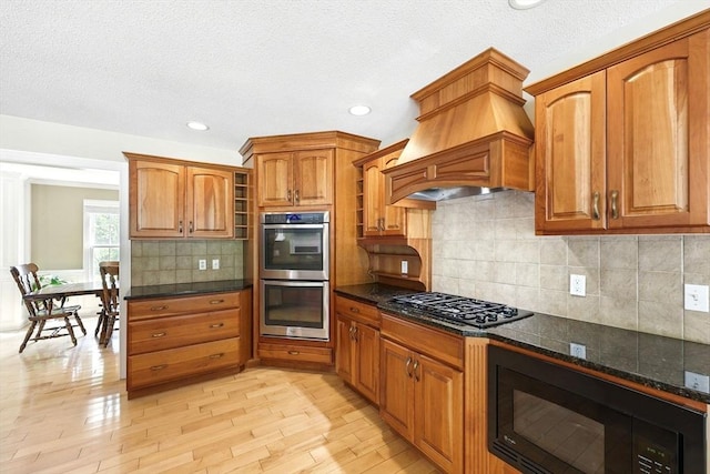 10 Tigger Ln, South Hadley, MA 01075 - kitchen with black appliances, light wood-type flooring, brown cabinets, premium range hood, and recessed lighting