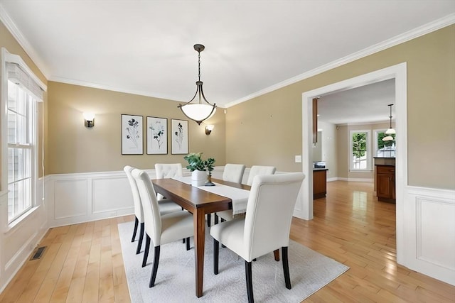 10 Tigger Ln, South Hadley, MA 01075 - dining room featuring light wood-style floors, a wainscoted wall, crown molding, and a decorative wall