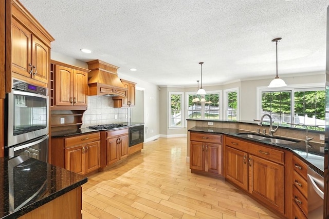 10 Tigger Ln, South Hadley, MA 01075 - kitchen featuring premium range hood, stainless steel appliances, backsplash, brown cabinetry, and decorative light fixtures