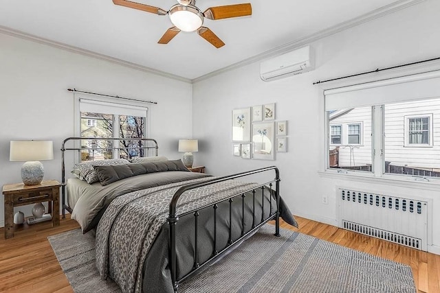 bedroom with radiator, hardwood / wood-style flooring, ornamental molding, ceiling fan, and a wall unit AC