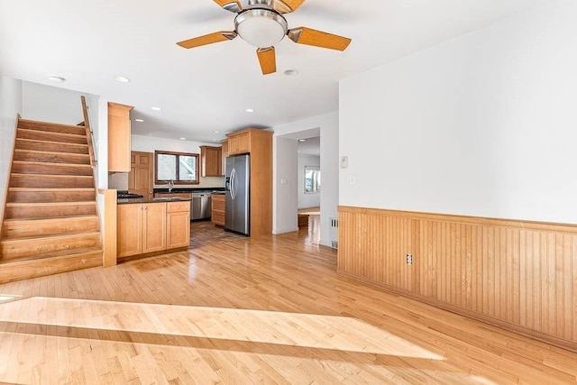 kitchen featuring ceiling fan, stainless steel appliances, sink, and light wood-type flooring