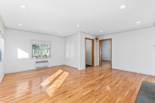 unfurnished living room featuring crown molding, radiator, and light wood-type flooring