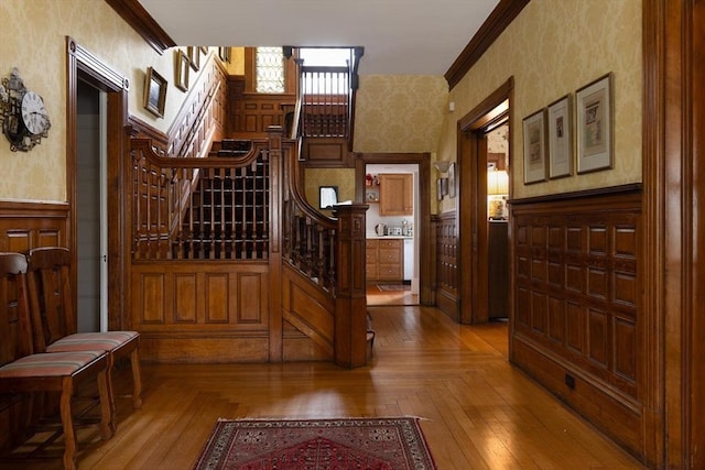 interior space with wallpapered walls, wainscoting, and stairs