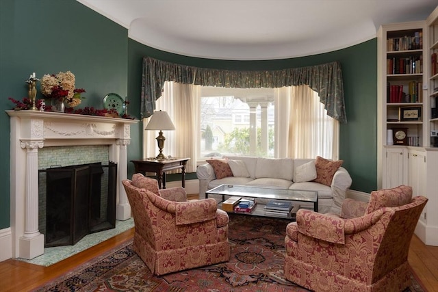 living room with wood finished floors and a fireplace with flush hearth