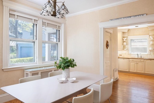 87 Crowninshield Rd, Brookline, MA 02446 - dining area with crown molding, plenty of natural light, light wood-type flooring, and a notable chandelier