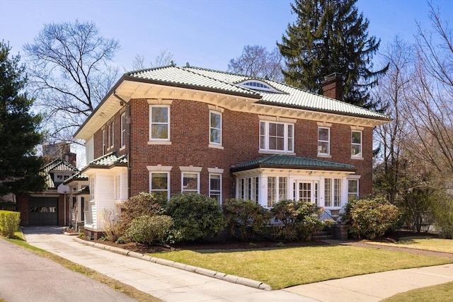87 Crowninshield Rd, Brookline, MA 02446 - view of front facade with a garage, a front yard, a chimney, brick siding, and a tile roof