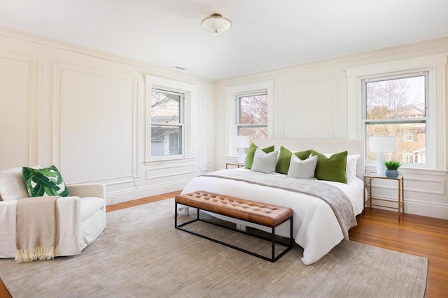87 Crowninshield Rd, Brookline, MA 02446 - bedroom with wood finished floors, crown molding, and a decorative wall