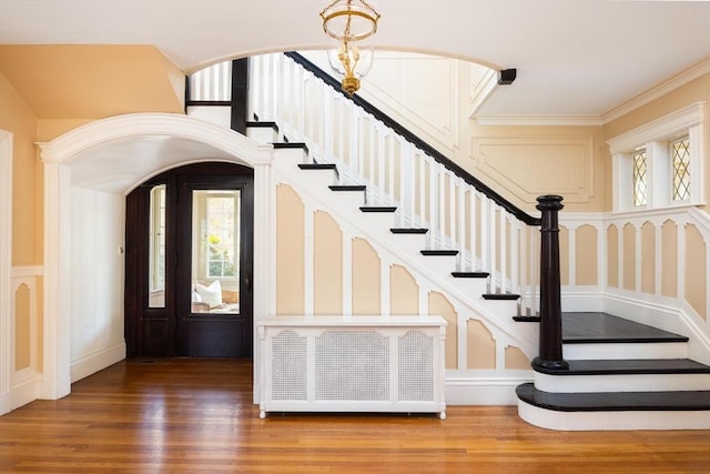 87 Crowninshield Rd, Brookline, MA 02446 - foyer entrance featuring crown molding, wood finished floors, stairway, and an inviting chandelier