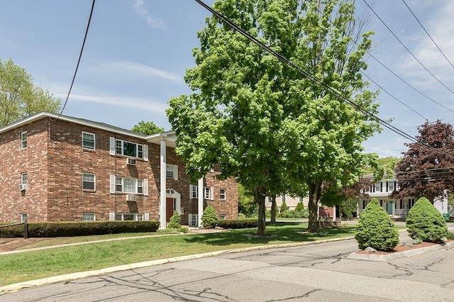view of front of home with brick siding and a front yard