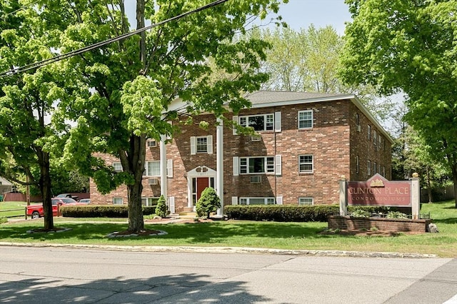 view of front of house featuring brick siding and a front yard