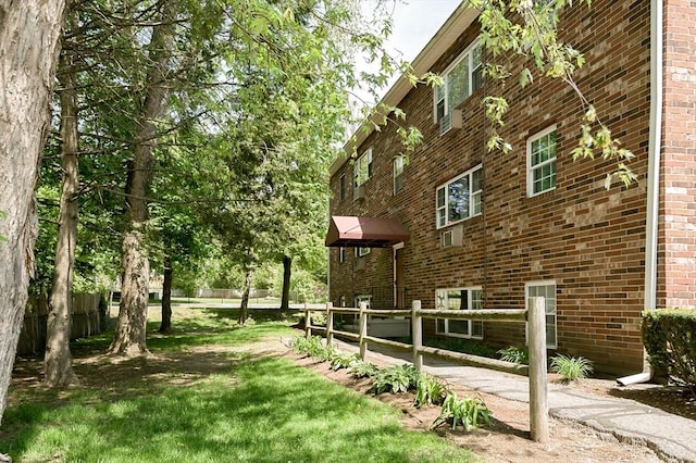 view of home's exterior with brick siding and fence