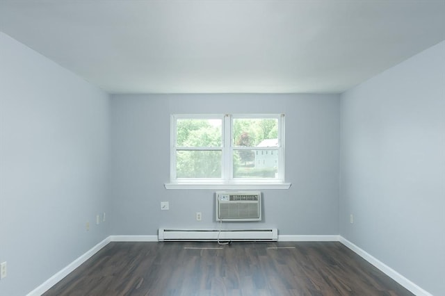 spare room with a wall unit AC, a baseboard heating unit, dark wood-style floors, and baseboards