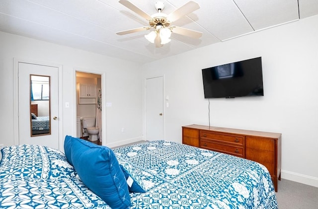 carpeted bedroom with ensuite bathroom and ceiling fan