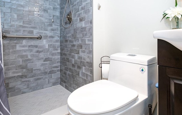 bathroom featuring vanity, toilet, and a tile shower