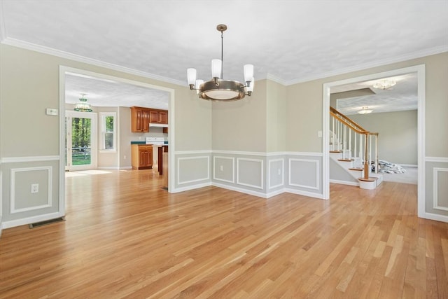 94 Old Right Rd, Ipswich, MA 01938 - spare room with a chandelier, light wood-style flooring, stairway, crown molding, and wainscoting