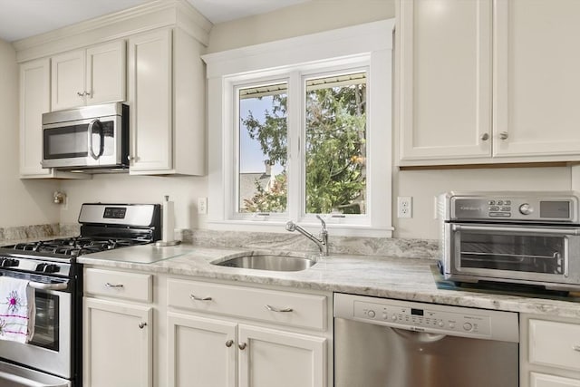 16 Field Rd Unit 16, Arlington, MA 02476 - kitchen with stainless steel appliances, white cabinetry, and light stone counters