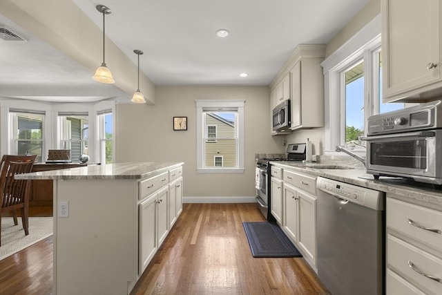 16 Field Rd Unit 16, Arlington, MA 02476 - kitchen featuring appliances with stainless steel finishes, a center island, wood finished floors, hanging light fixtures, and recessed lighting