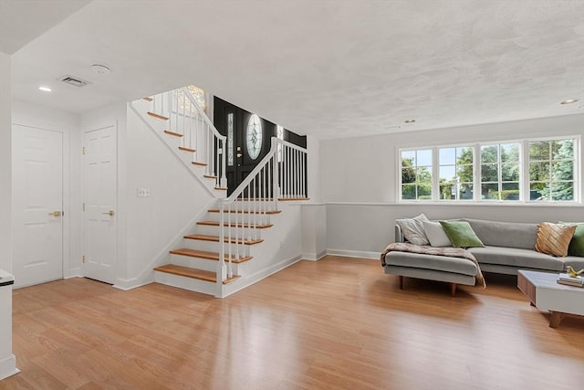 4 Blacksmith Way, Saugus, MA 01906 - living area featuring light wood finished floors, stairway, baseboards, and recessed lighting