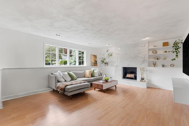 4 Blacksmith Way, Saugus, MA 01906 - living area featuring wood finished floors, built in shelves, baseboards, and a high end fireplace